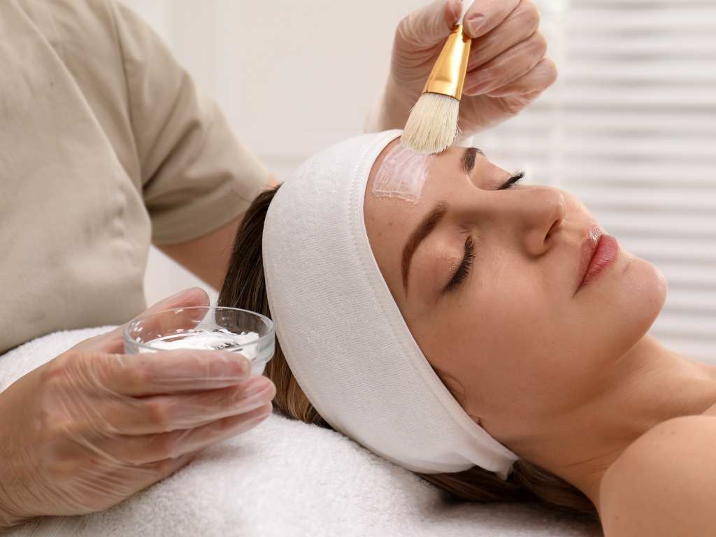 an elvy beautician applying the chemical peel on a woman's face.